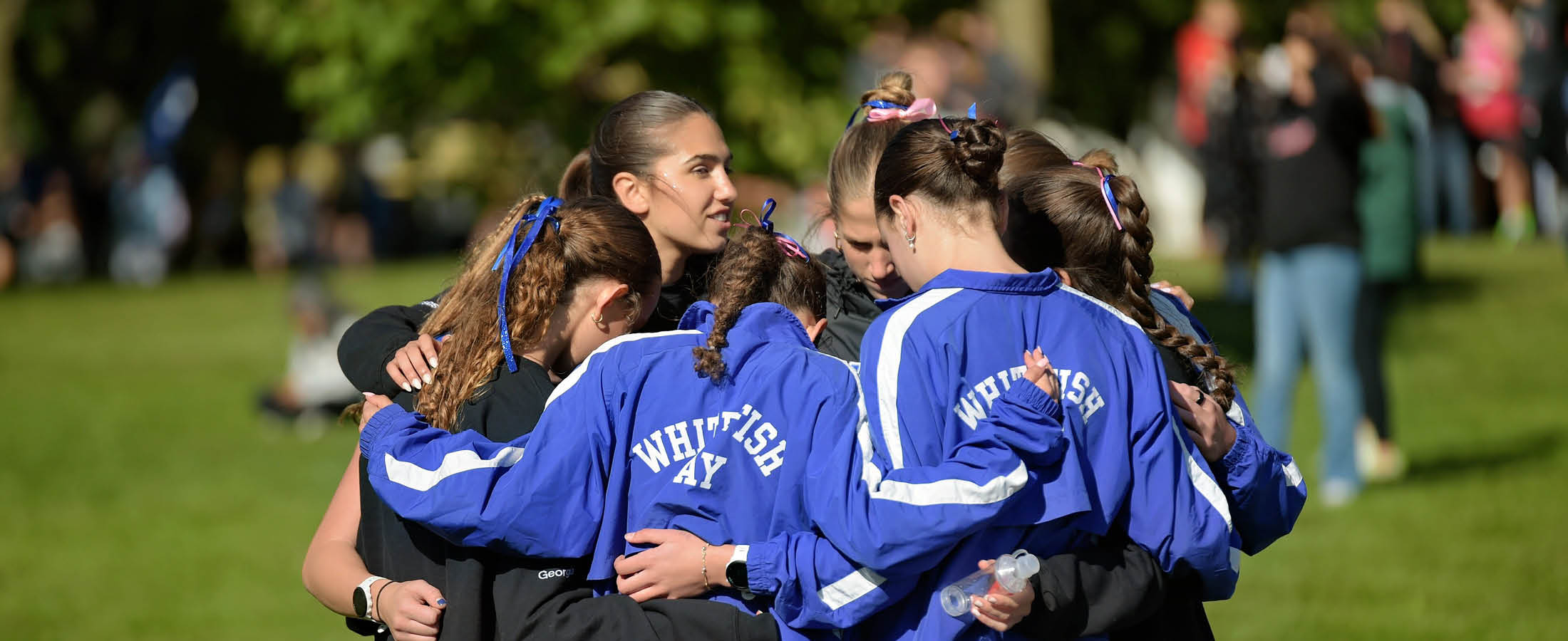 Girls Cross Country team in a huddle