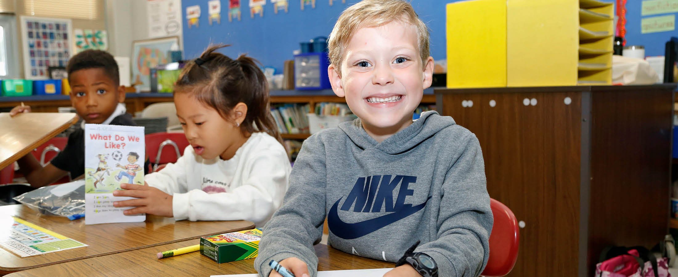Student smiling at desk