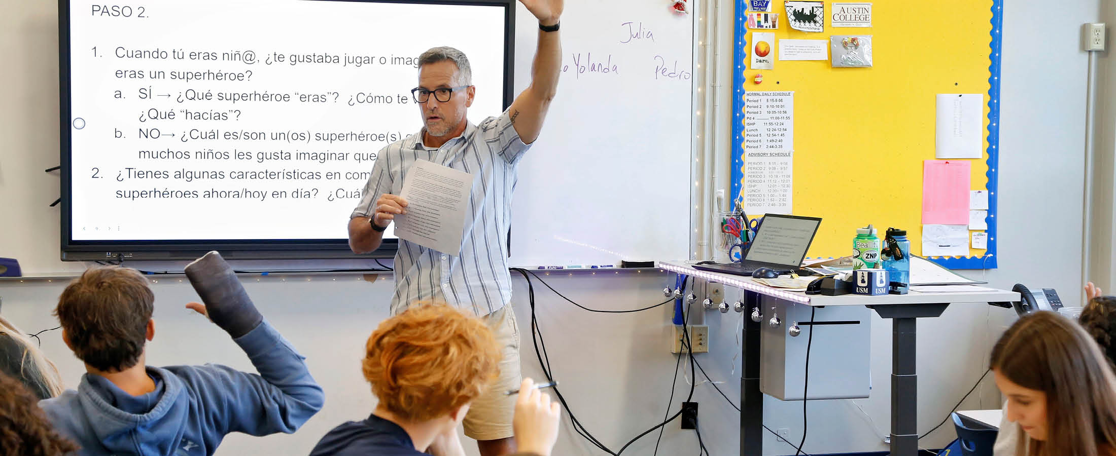 Students and teacher raising hand