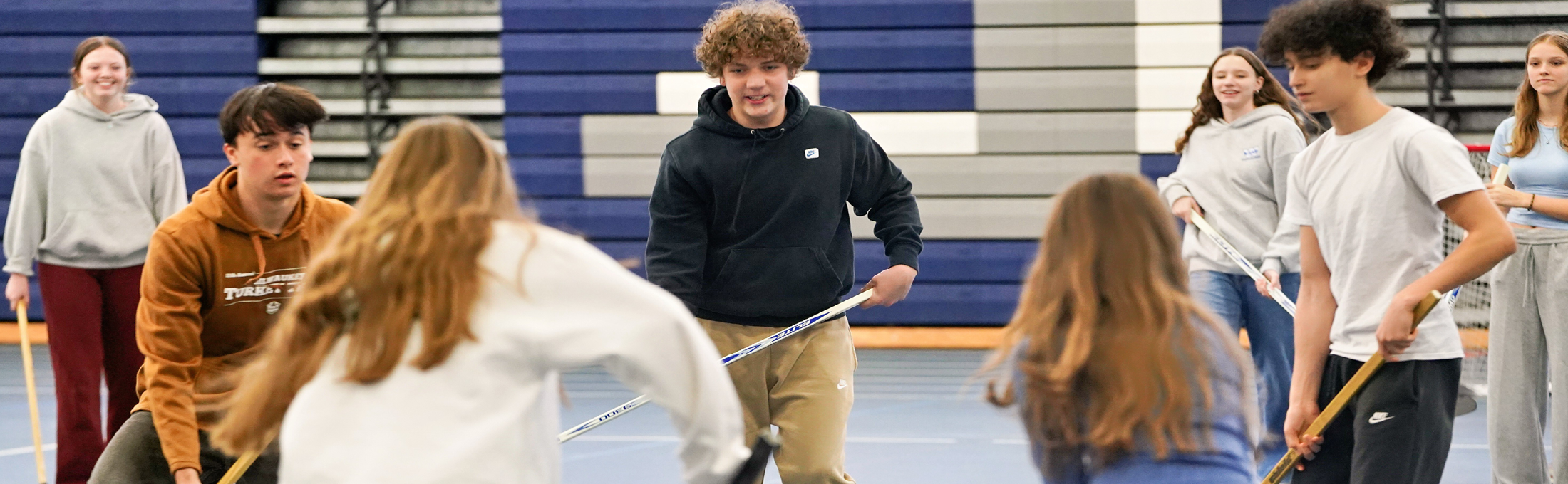 Students playing floor hockey
