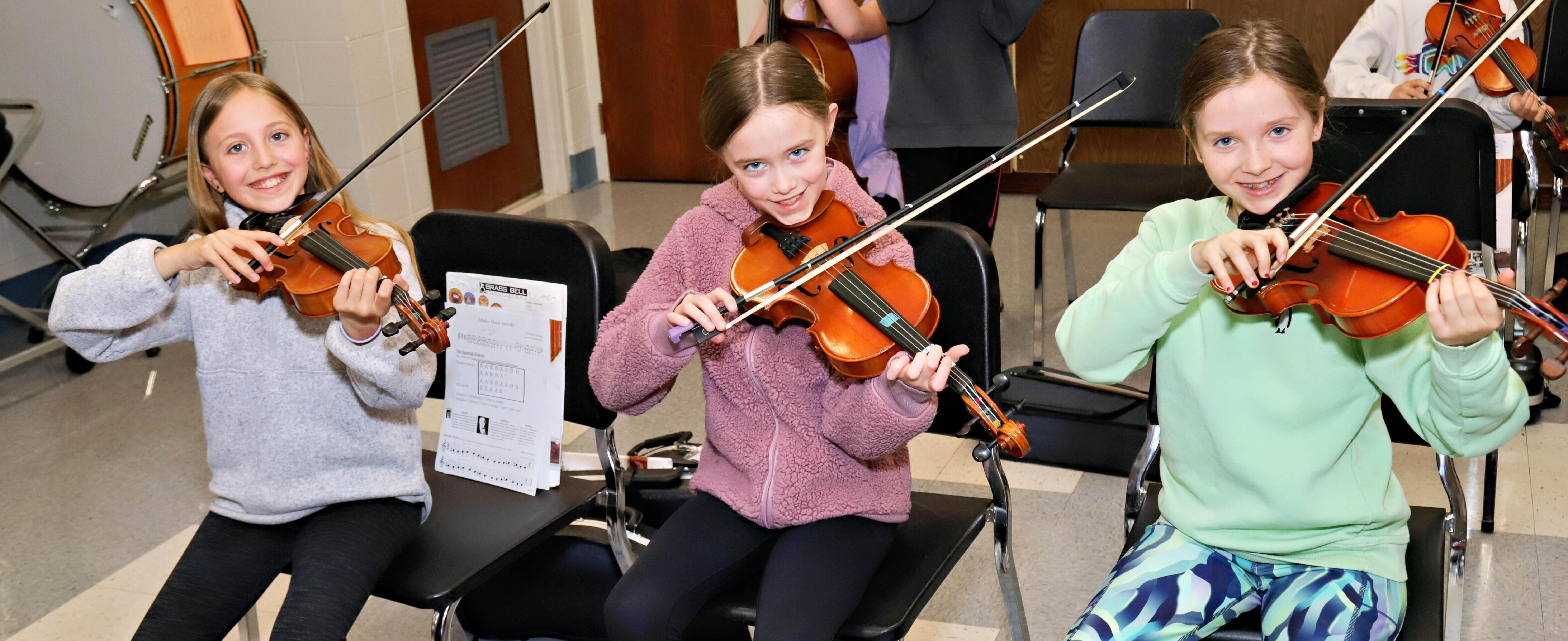 Three students playing instruments