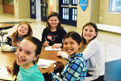 Students at tables writing